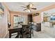 A dining room with a dark table, wine rack, ceiling fan, and view into the kitchen at 12306 91St Ter, Seminole, FL 33772