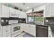 Clean kitchen featuring white cabinets, black countertops, and views of the outdoor space at 12306 91St Ter, Seminole, FL 33772