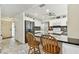 Open concept kitchen featuring white cabinets, black countertops, and a breakfast bar with wooden stools at 12306 91St Ter, Seminole, FL 33772