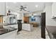 Bright kitchen featuring white cabinets, black counters, a modern refrigerator, and open access to the dining area at 12306 91St Ter, Seminole, FL 33772