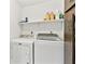 Functional laundry room equipped with a washer, dryer, overhead shelf and convenient cabinet storage at 12306 91St Ter, Seminole, FL 33772