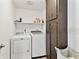 Functional laundry room equipped with a washer, dryer, overhead shelf and convenient cabinet storage at 12306 91St Ter, Seminole, FL 33772