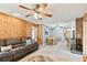 Cozy living room with wood paneling, a comfortable gray couch, and a view into the dining area at 12306 91St Ter, Seminole, FL 33772