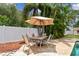 Outdoor patio area featuring a tile-topped table and chairs with an umbrella and lush tropical landscaping at 12306 91St Ter, Seminole, FL 33772