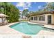 Backyard pool surrounded by brick pavers, lush tropical landscaping, and an adjacent shed for storage at 12306 91St Ter, Seminole, FL 33772