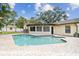 Backyard pool surrounded by brick pavers, lush tropical landscaping, and an adjacent shed for storage at 12306 91St Ter, Seminole, FL 33772