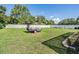 Large, grassy backyard with a white fence and a utility trailer at 13386 Lawrence St, Spring Hill, FL 34609