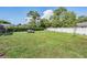 Expansive backyard with lush green grass, white fencing, and mature trees at 13386 Lawrence St, Spring Hill, FL 34609