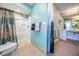 Bright bathroom featuring a shower, toilet, and vanity with neutral tile floors and turquoise walls at 13386 Lawrence St, Spring Hill, FL 34609