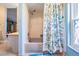 This clean bathroom features a tub with shower, seashell pattern shower curtain, and patterned seashell bath mat at 13386 Lawrence St, Spring Hill, FL 34609