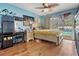 This bedroom offers wood floors, a sliding glass door to the lanai and pool, and a ceiling fan at 13386 Lawrence St, Spring Hill, FL 34609