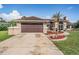 Charming home boasts a two-car garage, mature landscaping, and a welcoming front entrance at 13386 Lawrence St, Spring Hill, FL 34609