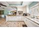 Bright kitchen featuring wood-look tile, stainless appliances, granite counters, and ample cabinet space at 13386 Lawrence St, Spring Hill, FL 34609