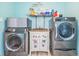 Laundry room with two machines, a decorated utility sink and laundry supplies on shelf at 13386 Lawrence St, Spring Hill, FL 34609