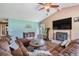 Relax in this living room with hardwood floors, a ceiling fan, and a fireplace with a marble surround at 13386 Lawrence St, Spring Hill, FL 34609