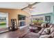 Relax in this living room with hardwood floors, a ceiling fan, and a fireplace with a marble surround at 13386 Lawrence St, Spring Hill, FL 34609