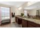 Bathroom with double vanity featuring granite countertop and a large mirror at 13913 Felix Will Rd, Riverview, FL 33579