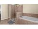 Bathroom featuring a glass shower, soaking tub with chrome fixtures, and neutral tile at 13913 Felix Will Rd, Riverview, FL 33579