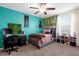 Bedroom with bed and desk area decorated with vines, paintings, and shelves at 13913 Felix Will Rd, Riverview, FL 33579
