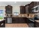 Stylish kitchen features stainless steel appliances and dark wood cabinetry at 13913 Felix Will Rd, Riverview, FL 33579