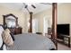 Main bedroom with canopy bed frame, wood flooring visible through entryways, and a ceiling fan at 13913 Felix Will Rd, Riverview, FL 33579