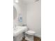Clean and modern bathroom with a pedestal sink, large round mirror, and a toilet at 146 26Th Ne Ave, St Petersburg, FL 33704