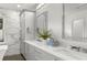 Bright bathroom with double sinks, sleek cabinets, a large mirror, and a marble tiled wall at 146 26Th Ne Ave, St Petersburg, FL 33704