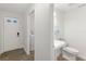Modern bathroom with a pedestal sink, toilet, and a view into the laundry room at 146 26Th Ne Ave, St Petersburg, FL 33704