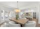 Elegant dining room with a rustic wood table, chic white chairs, and views of the modern kitchen at 146 26Th Ne Ave, St Petersburg, FL 33704