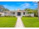 Charming home with manicured lawn and inviting walkway to a covered porch with American flag at 146 26Th Ne Ave, St Petersburg, FL 33704