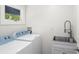 Functional laundry room with modern washer and dryer units and a utility sink at 146 26Th Ne Ave, St Petersburg, FL 33704