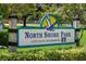 Welcoming sign for North Shore Park in St. Petersburg, featuring a pelican, set amidst lush green foliage at 146 26Th Ne Ave, St Petersburg, FL 33704