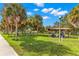 Scenic park featuring picnic shelter, lush greenery, and towering palm trees against a clear blue sky with fluffy clouds at 146 26Th Ne Ave, St Petersburg, FL 33704
