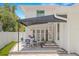 Charming outdoor patio with a dining table, awning, and access to the home via double French doors at 146 26Th Ne Ave, St Petersburg, FL 33704