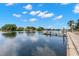 Beautiful waterfront view with a dock, calm waters, and houses under a blue sky with fluffy clouds at 146 26Th Ne Ave, St Petersburg, FL 33704