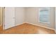 Bright bedroom with light walls, wood floors, a window, and a closed door at 1502 Marsh Wood Dr, Seffner, FL 33584