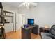 Light bedroom with wood floors, a ceiling fan, a desk, and an open closet at 1502 Marsh Wood Dr, Seffner, FL 33584