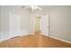 Spacious bedroom with wood floors, a ceiling fan, and a doorway leading to another room at 1502 Marsh Wood Dr, Seffner, FL 33584