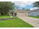 Charming single-story home with a spacious driveway, two-car garage, and manicured lawn at 1502 Marsh Wood Dr, Seffner, FL 33584
