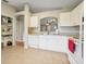 Bright white kitchen includes stainless steel sink and tile floors for easy cleanup at 1502 Marsh Wood Dr, Seffner, FL 33584