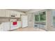 Open kitchen offers backyard views, white appliances, and tile floors at 1502 Marsh Wood Dr, Seffner, FL 33584