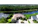 Stunning aerial view of the waterfront property with lush landscaping, long driveway and mature trees at 15415 Mulholland Rd, Parrish, FL 34219
