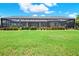 Expansive backyard view of the screened-in pool area with mature landscaping and well-manicured lawn at 15415 Mulholland Rd, Parrish, FL 34219