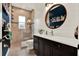 Bathroom showcases a modern vanity, wood-trimmed mirror, walk-in shower, and stylish decor at 15415 Mulholland Rd, Parrish, FL 34219