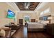 Main bedroom featuring dark hardwood floors, tray ceiling, and a large window at 15415 Mulholland Rd, Parrish, FL 34219