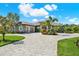 Beautiful home with a spacious driveway and tropical landscaping including palm trees, adding to the curb appeal at 15415 Mulholland Rd, Parrish, FL 34219