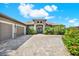Attractive house with a paved driveway and a charming entryway enhanced by palm trees and tropical foliage at 15415 Mulholland Rd, Parrish, FL 34219
