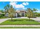 Charming single-story home featuring lush landscaping, a paver driveway, and a welcoming double-door entrance at 15415 Mulholland Rd, Parrish, FL 34219