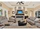 Stylish living room with a stone accent wall, modern fireplace, and comfortable seating arrangement at 15415 Mulholland Rd, Parrish, FL 34219