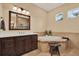 A well-appointed main bathroom with a soaking tub, tiled surround, and a dark wood vanity at 15415 Mulholland Rd, Parrish, FL 34219